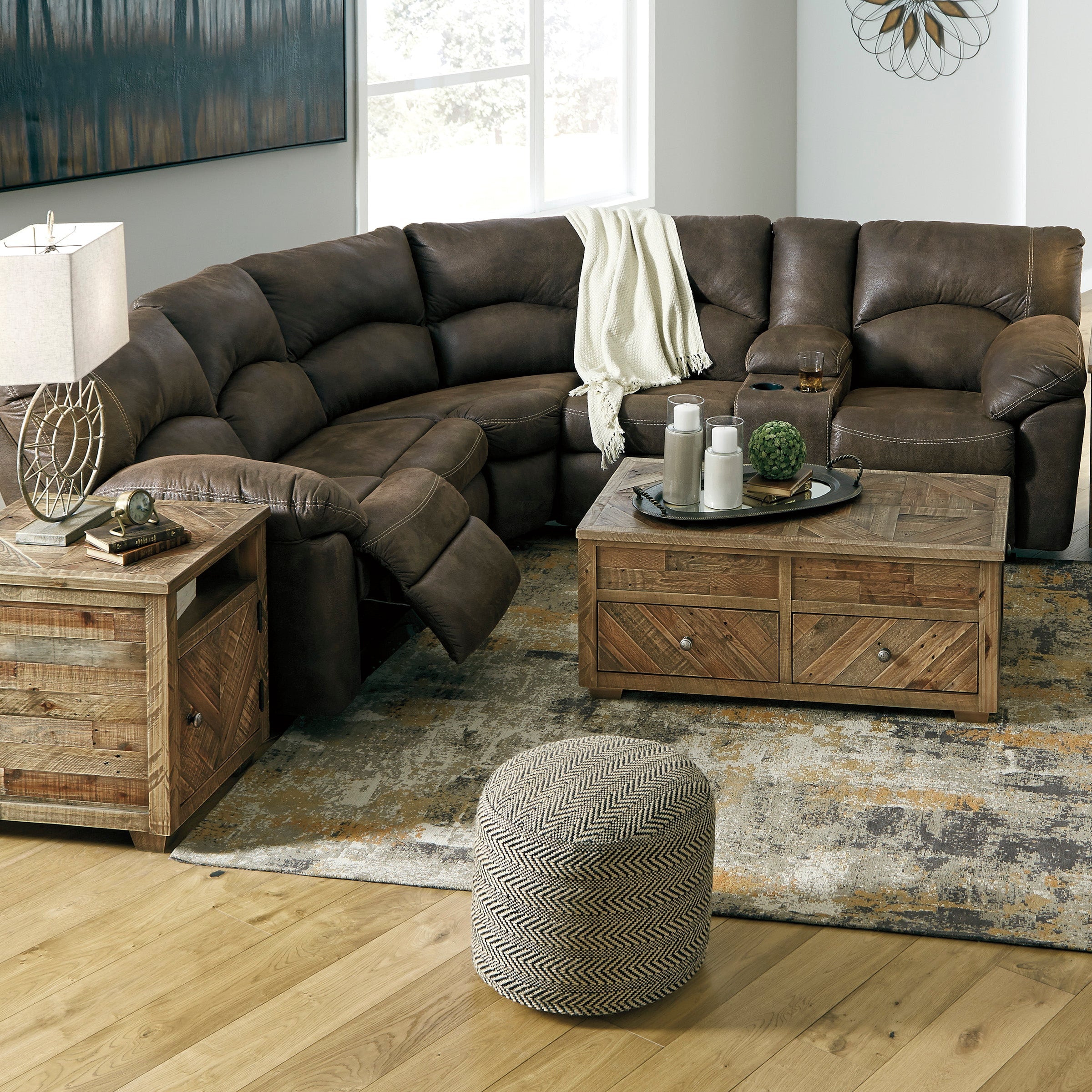 A brown faux vintage leather sectional sofa with plush cushions and wraparound pillow top arms, featuring a reclining loveseat configuration in a living room setting.