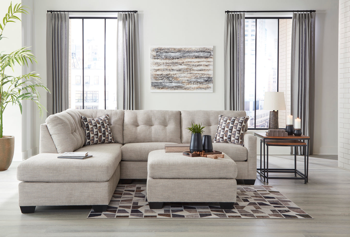 Living room with a sectional sofa, ottoman, and decorative items.