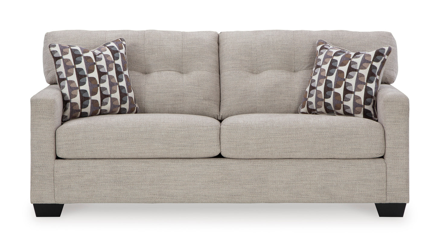 Gray sofa with patterned pillows on a white background