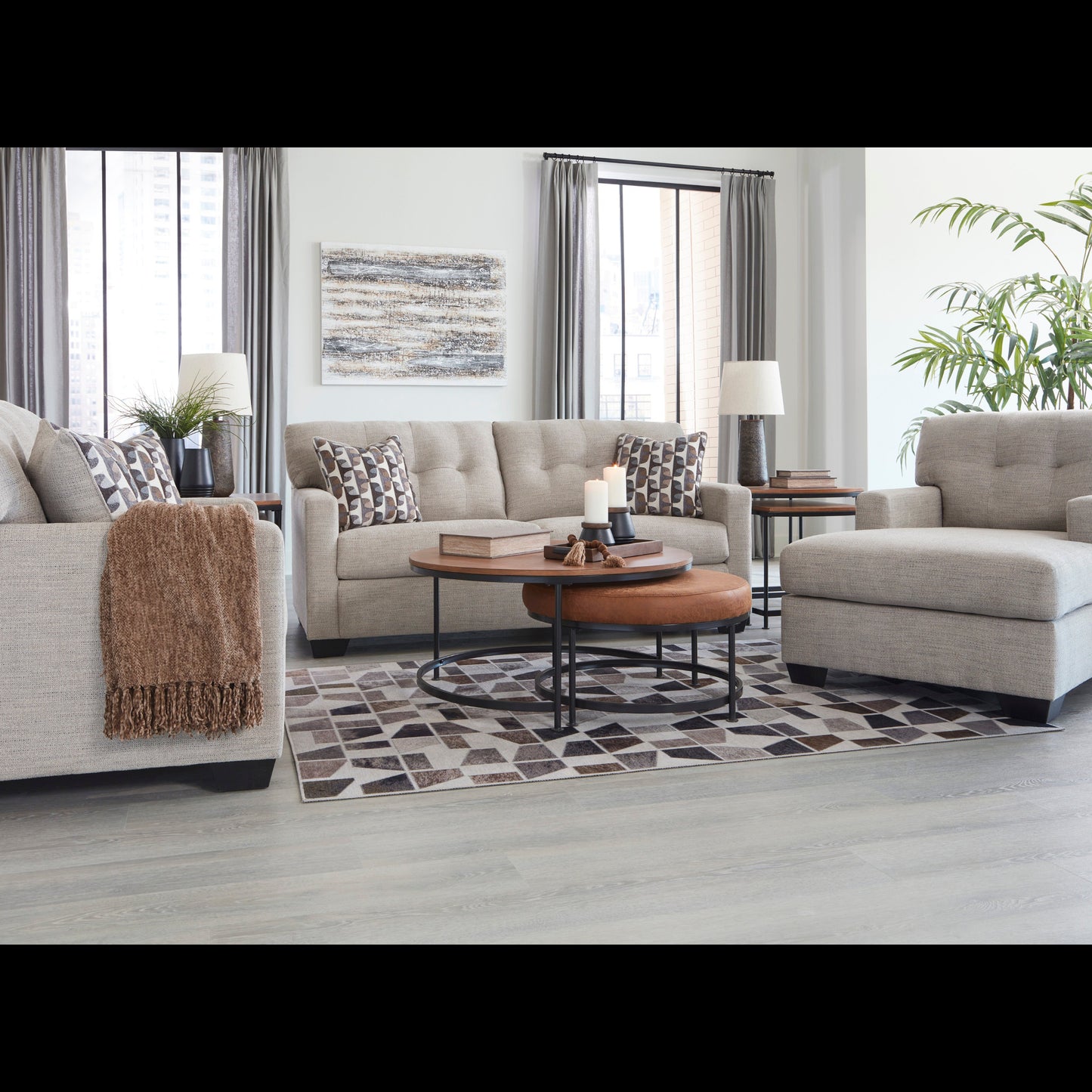 Living room with gray sofa, armchair, and coffee table on a patterned rug.
