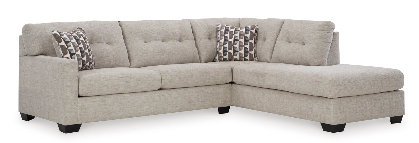 Beige sectional sofa with patterned pillows on a white background