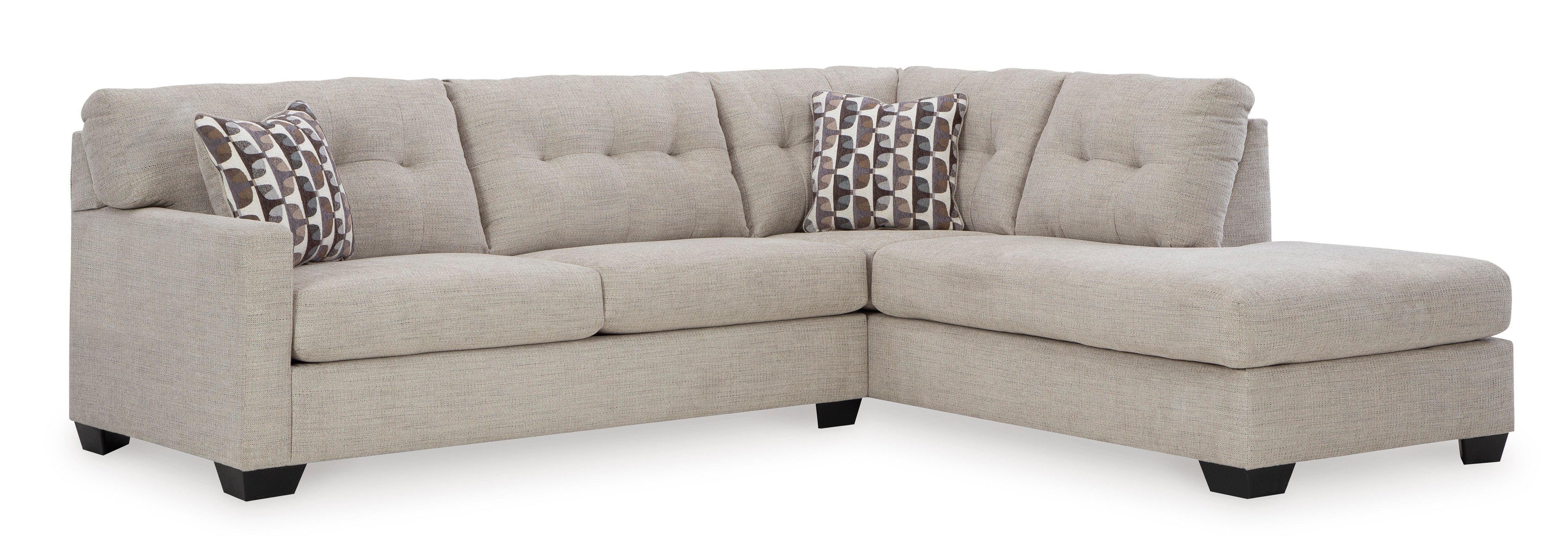 Beige sectional sofa with patterned pillows on a white background