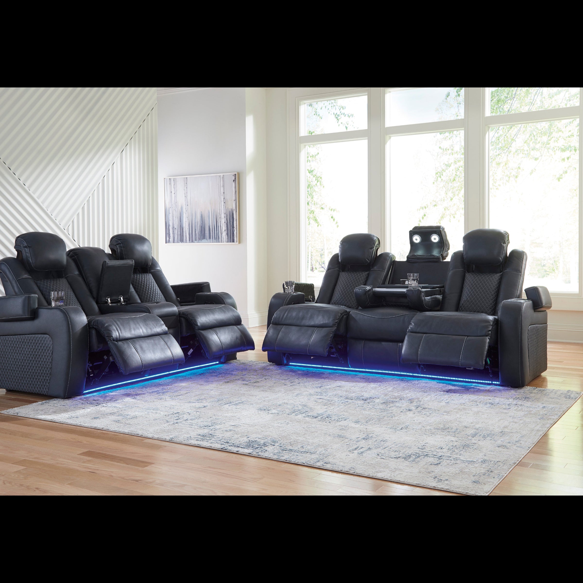 Modern black leather recliner chairs with LED lighting in a room with large windows.