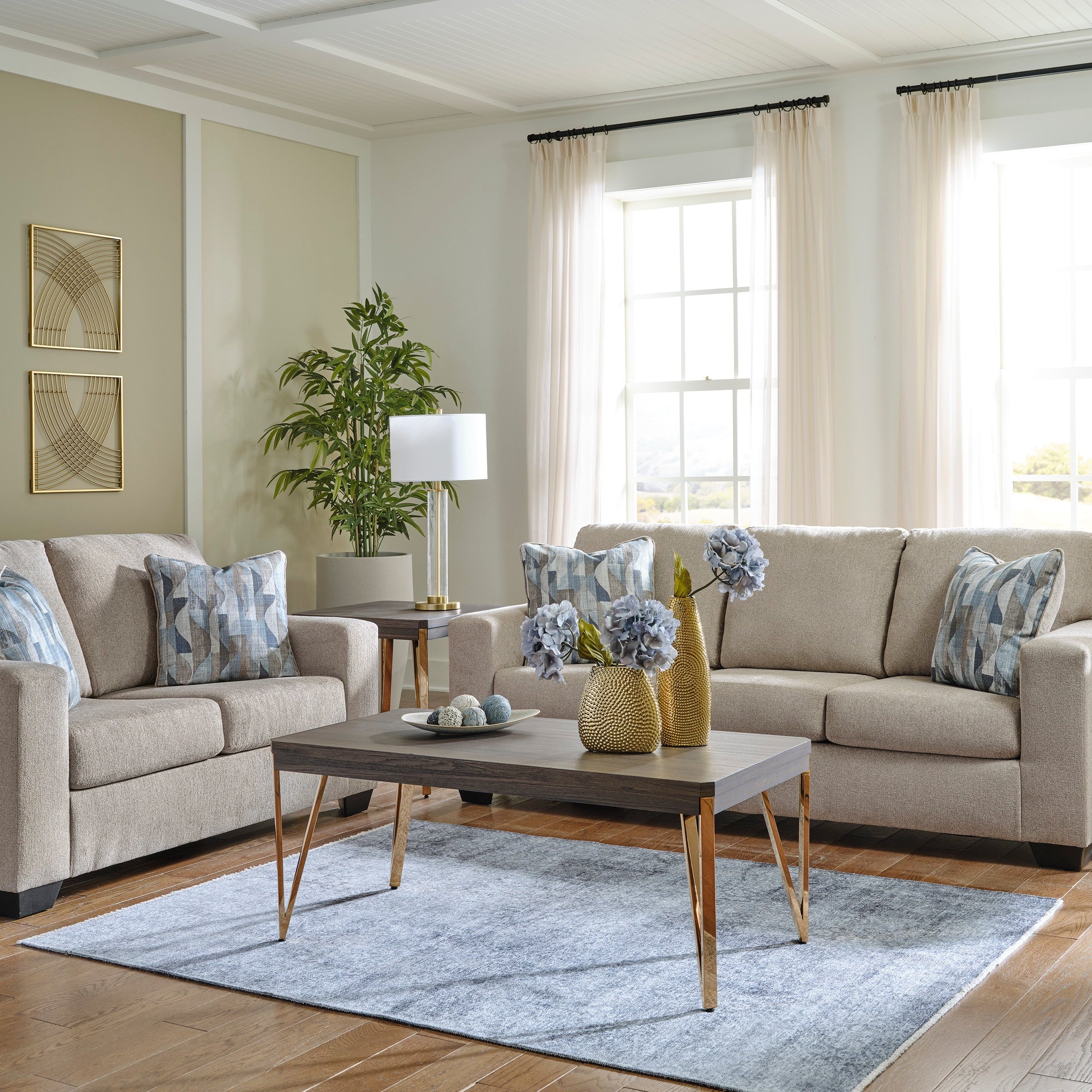 Living room with beige sofa set, coffee table, and decorative elements.