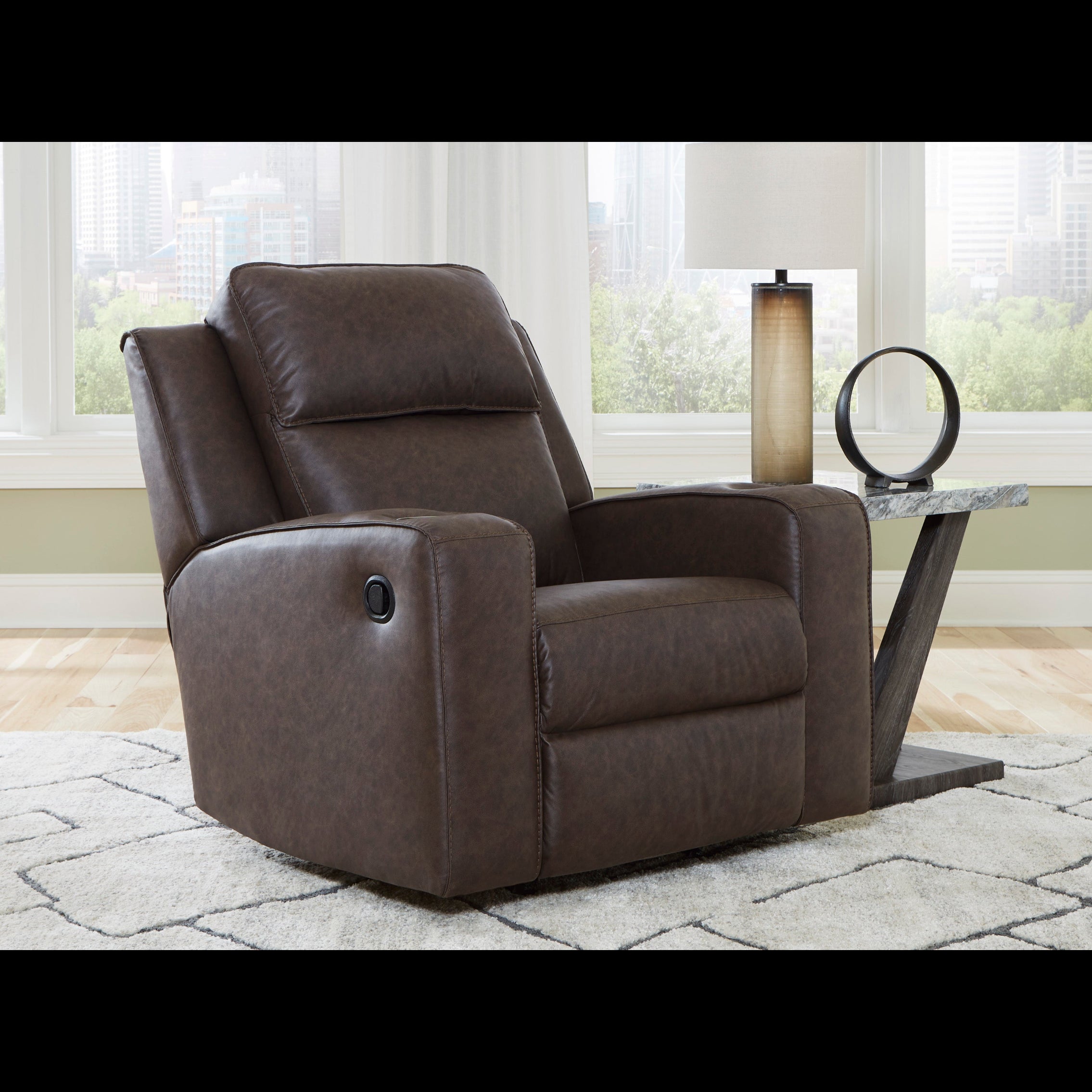 Brown recliner chair in a room with large windows and a side table.