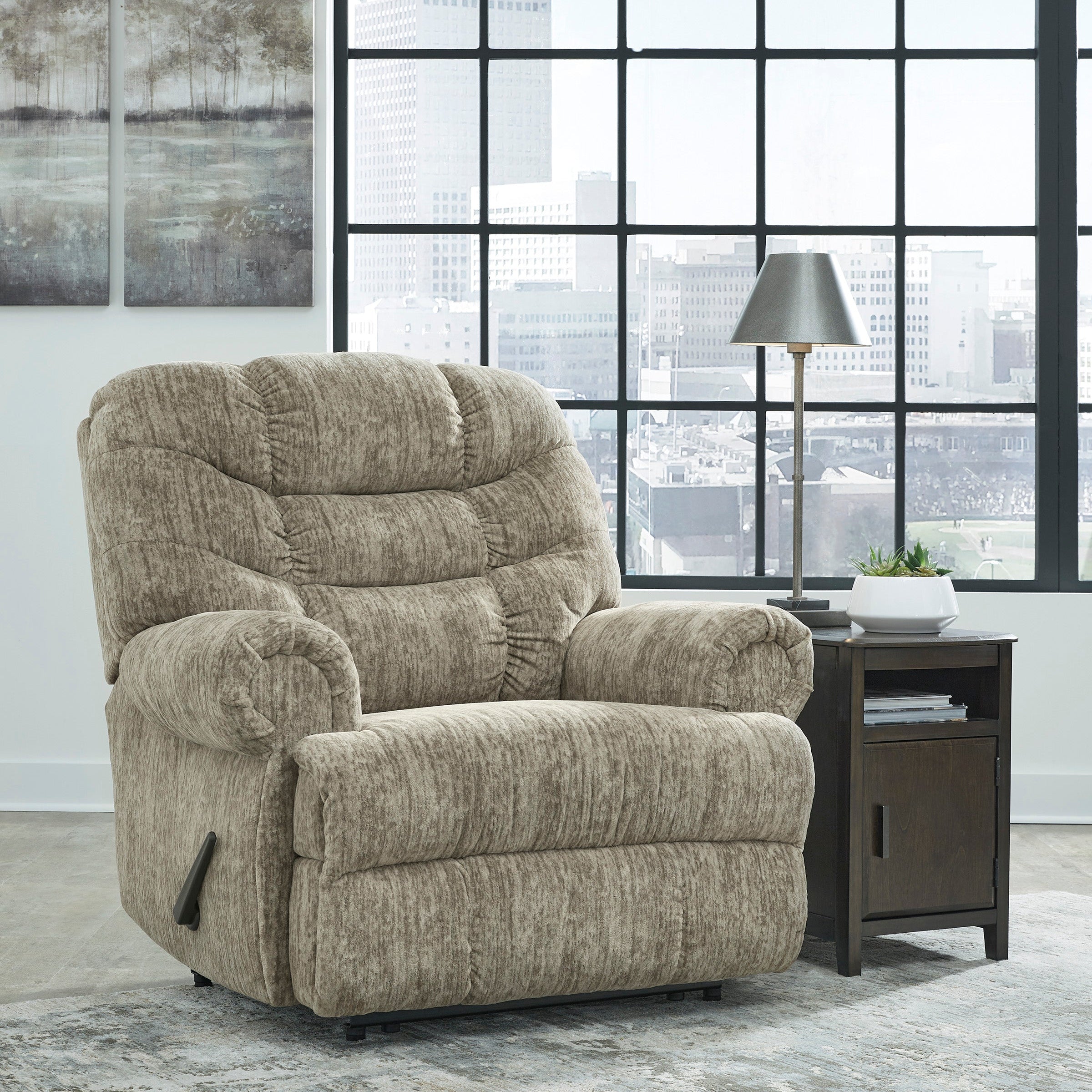 Beige recliner chair in a room with large windows and a side table.