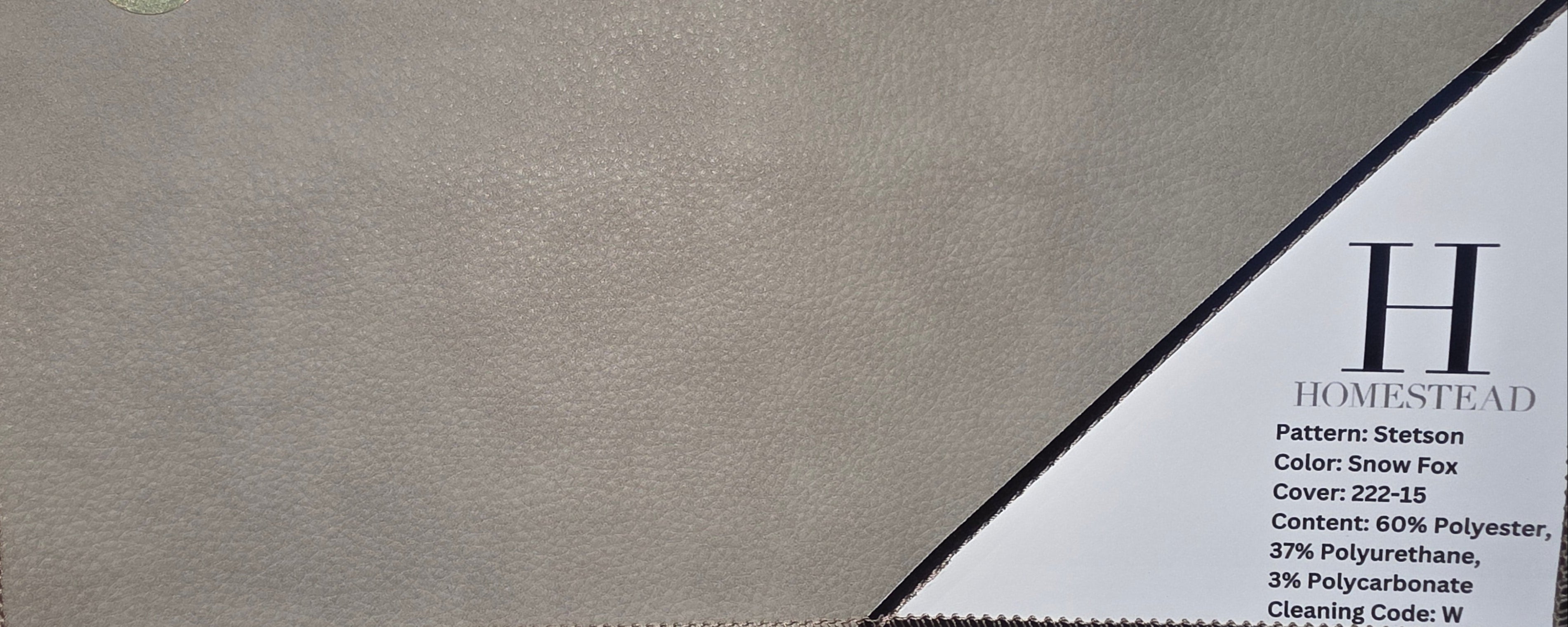 A close-up of a beige textured leather or faux-leather material sample with metal grommets, shown alongside printed fabric swatch information for the Homestead pattern.