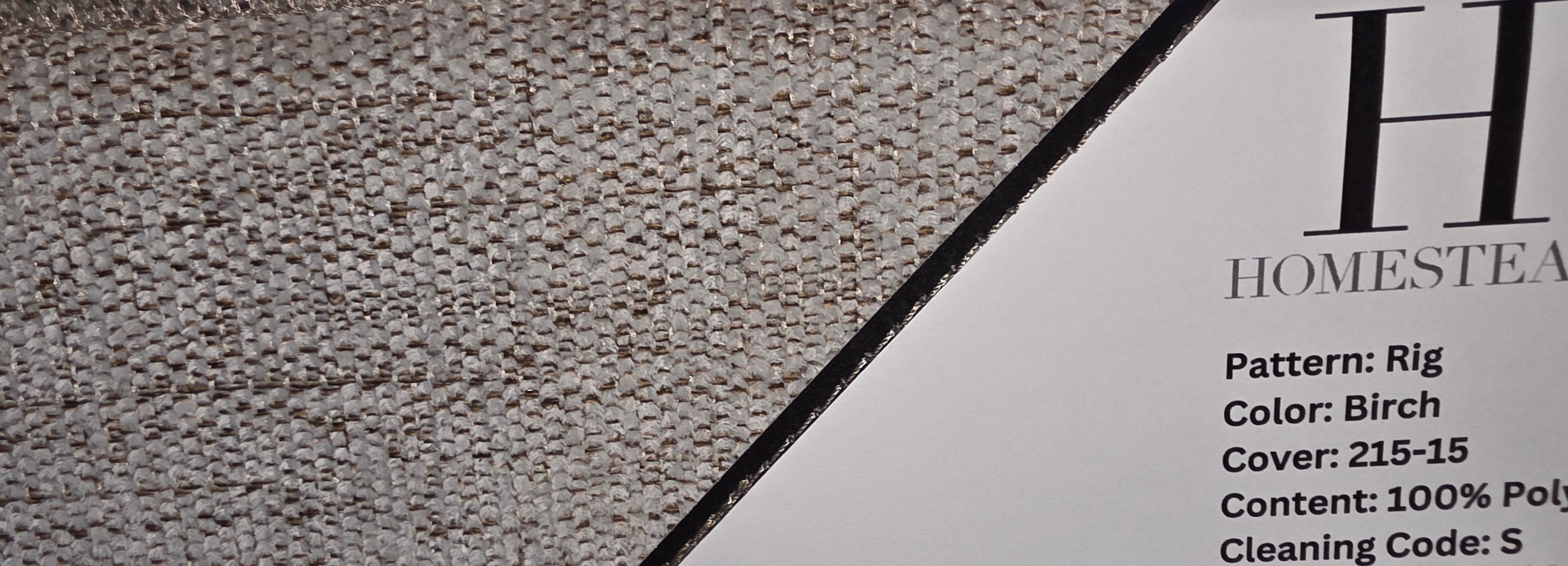 Close-up of a carpet or fabric sample swatch with visible weave texture, zigzag seam lines, and printed product information on a white card. The visible text includes 'HOMESTEA' and 'Color: Birch.