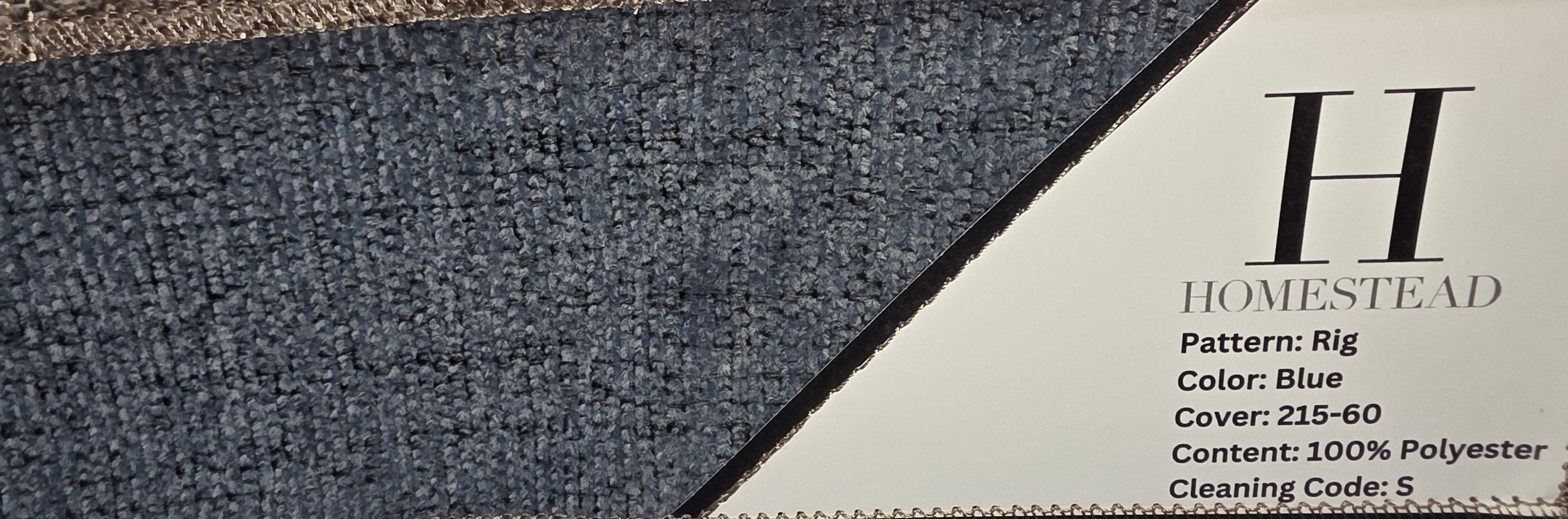 Two carpet samples displayed side by side on a stand, with printed labels showing Homestead branding and product details. The left sample is a dark blue textured rug, and the top-right sample is a warm taupe/beige rug.