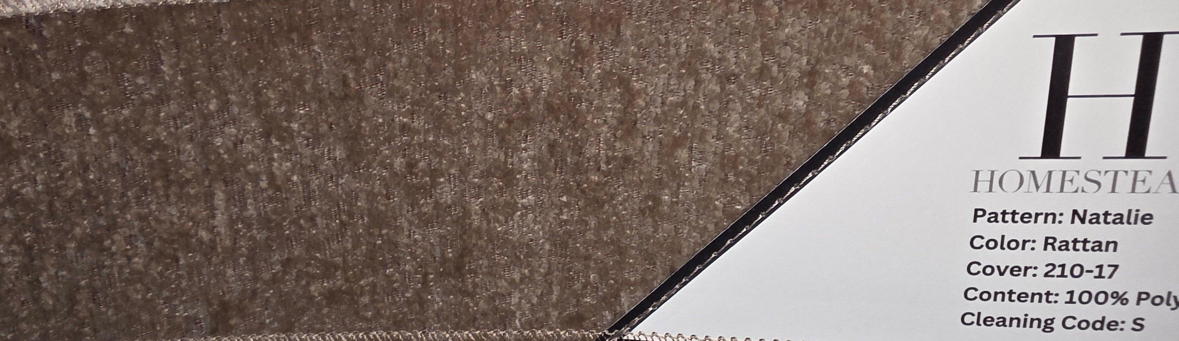 Close-up of fabric swatches with stitched edges and printed labels reading Homestead, showing textured material samples in taupe, beige, and ivory tones.