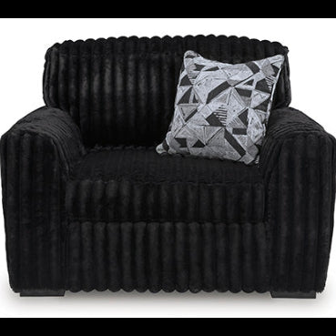 Black armchair with a patterned pillow on a white background