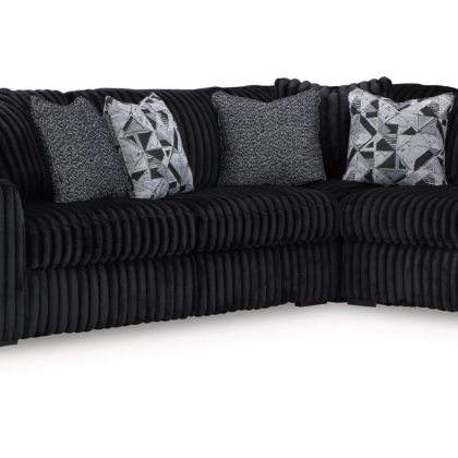 Black sectional sofa with patterned cushions on a white background