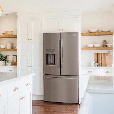 Modern kitchen with stainless steel refrigerator and white cabinets