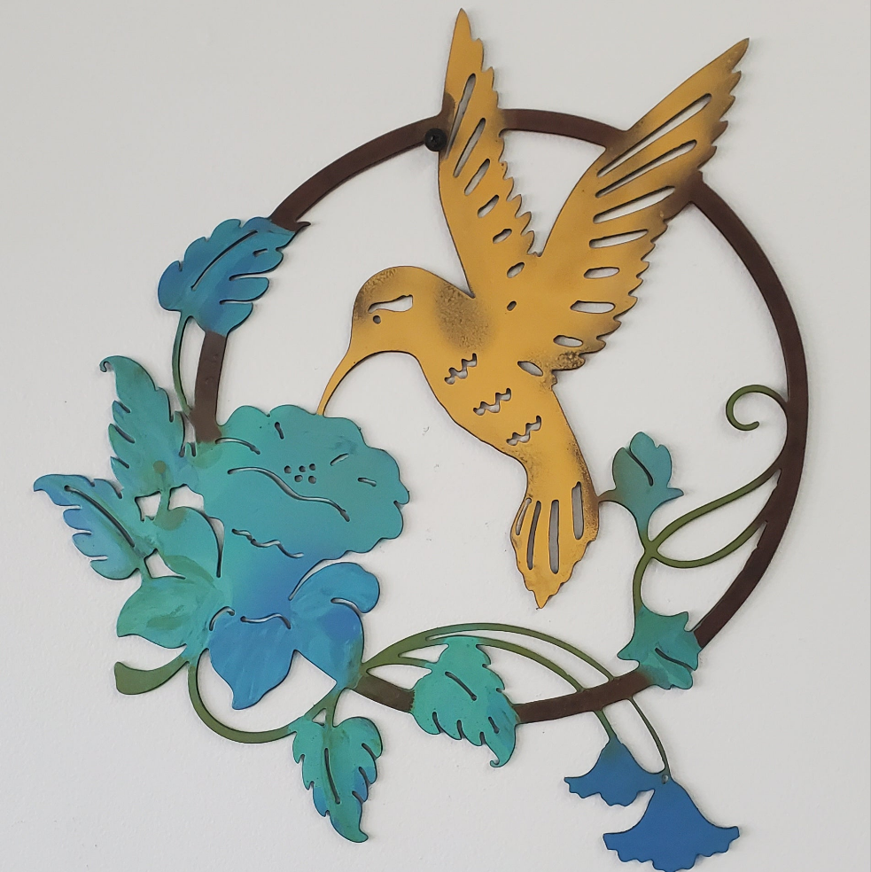 Decorative metal wall art featuring a hummingbird and flowers on a white background