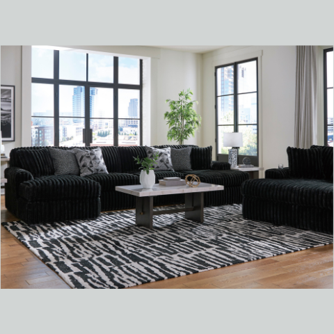 Modern living room with black sofa, coffee table, and decorative elements.
