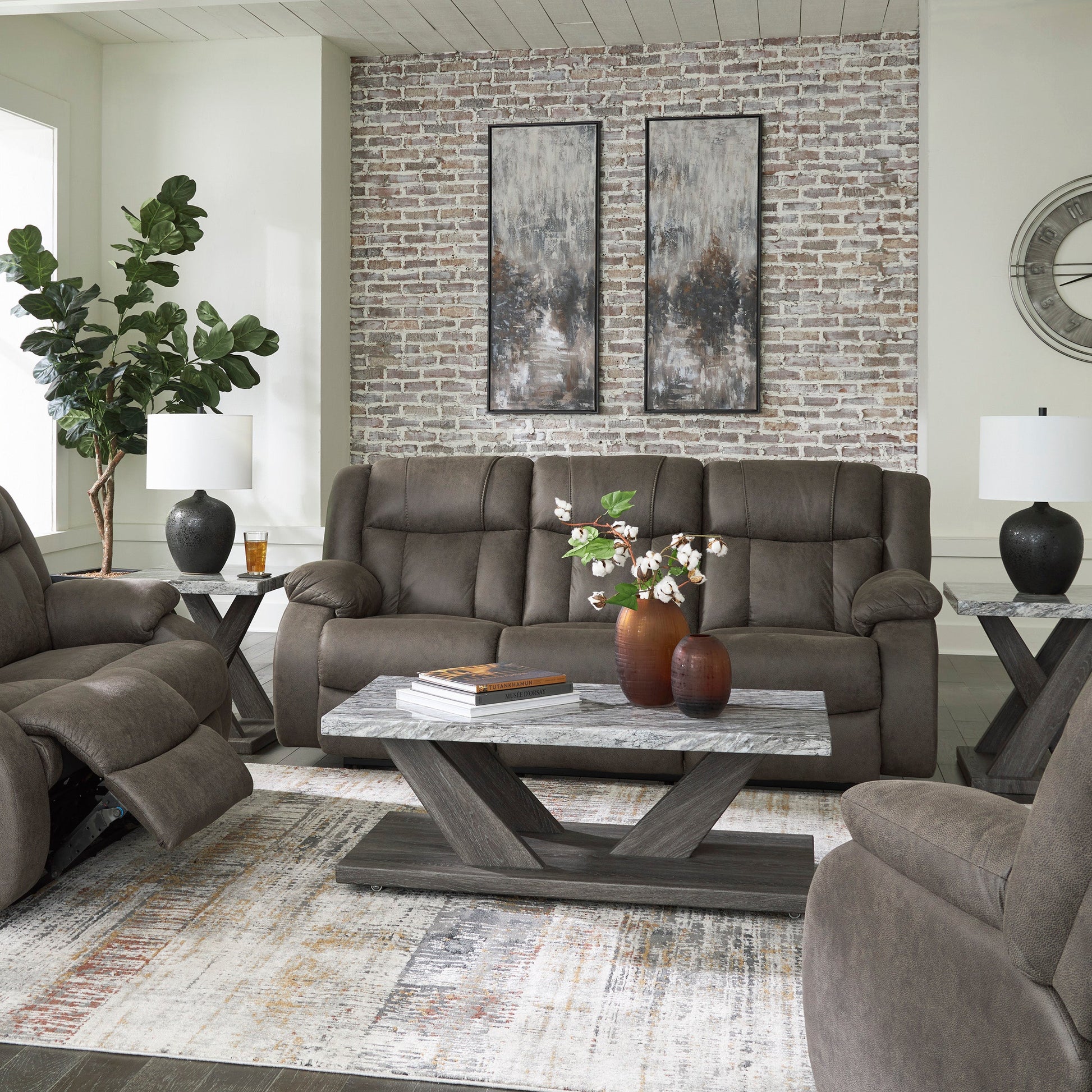 Gray reclining sofa set in a living room with decorative elements.